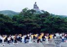 Practitioners hold group practice on Lantou Island, Hong Kong. Giant Buddha statue can be seen in the background.