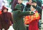 Published on 1/25/2001 一名女子二十五日拿着「法正乾坤」的法轮功标语，在北京天安门抗议，遭到警方拘捕。(美联社图片)