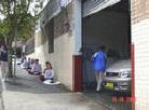 Published on 10/15/2001 A Chinese Consulate employee deliberately sprays water on Falun Gong practitioners sitting in meditation while he washes a car, Sydney, Australia, 2001.


