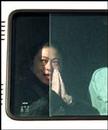 Published on 5/2/2000 A woman Falun Gong practitioner smiles and presses her hands in Heshi position to the outside from the window of a police van.