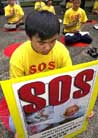 Published on 8/13/2001 Photo Collection: Media Report on Falun Gong March in Hong Kong. Falun Gong practitioners meditate in downtown Hong Kong on Friday, Aug. 10, 2001, as part of a three-day campaign demanding the release of Falun Gong follower Chan Yok-to who was arrested in Beijing on July 12, 2001 and calling on the Chinese government to stop persecution of the [group]’s members in the mainland. Some 20 members of the meditation [group] which is banned in mainland China but not in Hong Kong, also marched and delivered a petition to the Chinese liaison office in the territory. (AP Photo/Anat Givon)



