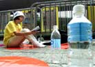 Published on 8/29/2001 Reuters’s Photo Report: HK Falun Gong in Fourth Day of Hunger Strike. A practitioner reads the book ’Zhuan Falun’ in front of bottles of water on the third day of a hunger strike outside the Chinese Liason Office in Hong Kong August 27, 2001 to protest against the imprisonment of followers in mainland China.
