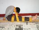 Published on 8/16/2004 A Practitioner in China Demonstrates Some of the Tortures Frequently Used on Practitioners in Detention. The torturers at the forced labor camps often bind detained Falun Gong practitioners to a ladder, forcing them to "sit parallel on the ladder" for extended periods of time. Not having access to a ladder, we demonstrated the torture using a board instead. The perpetrators seal practitioners’ mouths with tape to muffle their agonizing cries. They also bind practitioners’ hands behind their backs and use the tape to force their heads forward with their chins against their chests.

The ladder used in the actual torture is the type of metal ladder commonly used on the bunk beds found in prisons, labor camps and detention centers in China.

