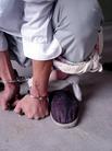 Published on 10/1/2004 山东潍坊劳教所迫害法轮功学员酷刑图示---将大法学员戴上手铐，逼迫蹲下后，用毛巾将大小腿固定住，再用一条毛巾将双手拴在脚腕上。
