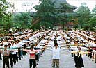 Practitioners perform Exercise One during large scale group practice in Chengdu, Central China.