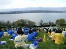Published on 8/1/2001 Falun Gong practitioners sit in meditation in the rain during group practice beside a lake in Geneva, Switzerland, April 2001.