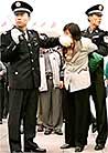Published on 10/1/2000 Uniformed Police Blocks a pracittioner’s mouth so that she can’t shout out "Falun Dafa is good"