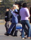 Published on 1/24/2002 美联社图片一：便衣警察和穿制服的警察带走一位外国法轮功支持者(中)。这位女士戴着写有“法轮功”和“SOS”字样的饰带，于2002年1月23日星期三在北京天安门广场上抗议中国对法轮功的镇压。她被迅速推入一辆守候的警车后拉走。