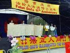 Displaying the Yellow Ribbon Imprinted with Petition Signatures  during Grand 'World Falun Dafa Day' Celebrations Held at Toronto City Hall Plaza on May 13, 2003